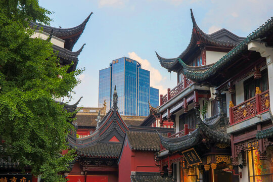 Historic temple roofs of the old town (Nanshi) creating a striking contrast with the modern Bund Finance Center (BFC) headquarter building rising above the city, Shanghai, China, 31 July 2026: 
