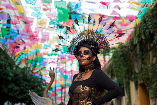 Woman With Day of the Dead Makeup Beneath Colorful Papel Picado Decorations