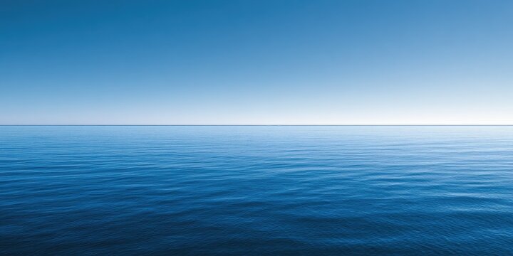 A vast expanse of deep blue ocean under a clear, bright sky