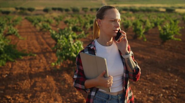 Female agricultural using connected digital tools to communicate and document field observations.Connected agriculture, smart technology, sustainable farming and agricultural management concept