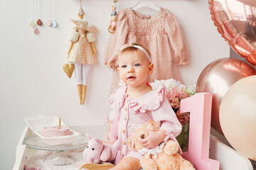 Fototapeta premium Adorable One Year Old Birthday Girl Celebrating First Birthday in Photo Studio with Cake, Balloons and Festive Decorations, Cake Smash Party, Happy Childhood Milestone Portrait