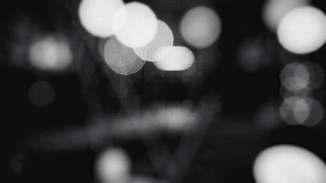 Blurred circular lights grainy monochrome photograph with shallow depth of field