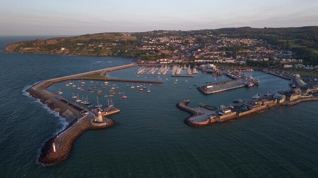 Beautiful drone panorama, birds eye of Howth Harbour and coastal village at sunset, Ireland