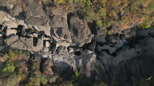 Sculpted quartzite bedrock of the Sao Miguel River at Vale da Lua, Chapada dos Veadeiros National Park, Alto Paraiso de Goias, Goias, Brazil, displays fluvial potholes and erosion channels, top-down