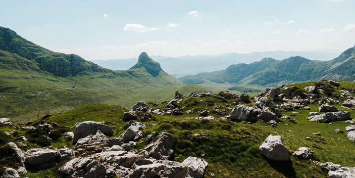 Rocky alpine landscape overlooking Sedlo Pass in Durmitor National Park, Montenegro. Limestone formations and rolling green mountains stretch toward the distant horizon