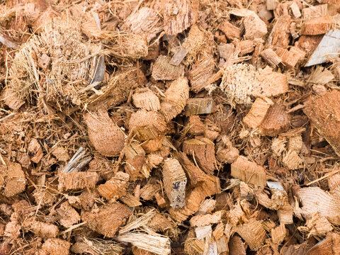 Texture of brown coconut husk chips and coir fibers used as gardening mulch