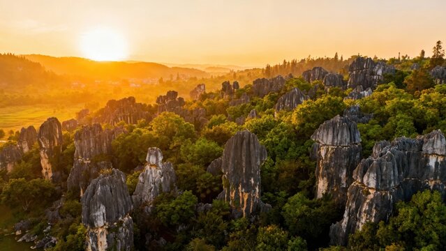 Sunset over a rocky karst landscape with lush greenery and towering limestone formations