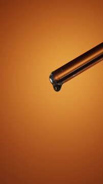 Macro of viscous liquid dripping from the tip of a glass rod