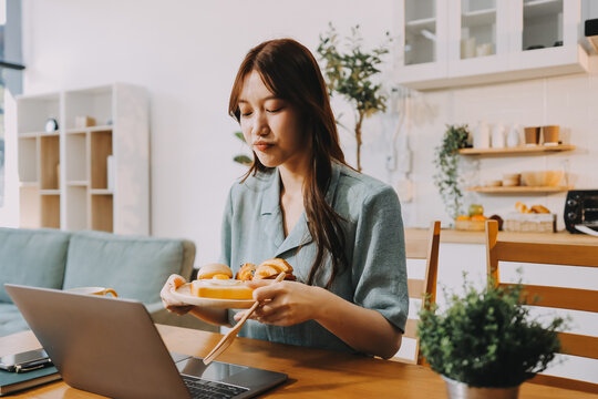 Happiness Entrepreneur beautiful business asian young woman wear casual use mobile phone for shopping online enjoy with social media and laptop at home.Small Business Startup.online banking