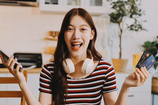 Happiness Entrepreneur beautiful business asian young woman wear casual use mobile phone for shopping online enjoy with social media and laptop at home.Small Business Startup.online banking