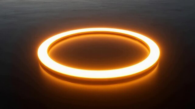 Glowing orange circular light fixture on dark reflective surface with warm illumination and soft shadow