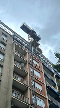 building facade with freight elevator for moving or renovation work, building under construction