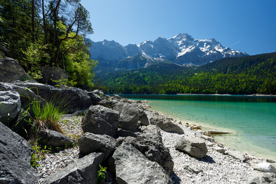 Travel landscape of Zugspitze Alps in Bavaria Germany, scenic summer nature panorama with forest, Eibsee lake, snow mountains peak. Alpine landscape