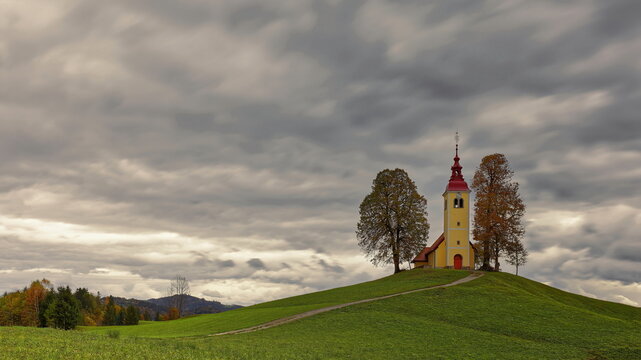 Undulating dirt trail going uphill to the Baroque, XVII c.Saint Thomas church (Cerkev svetega Tomaza) in Gorenji Vrsnik village. Idrija-Slovenia-197
