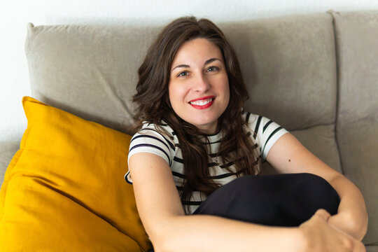 Woman smiling at home relaxing on sofa