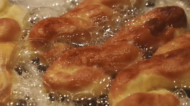 Golden Fried Dough Pastries Bubbling in Hot Oil Slow Motion Cooking Process Restaurant Bakery Food Preparation 4K