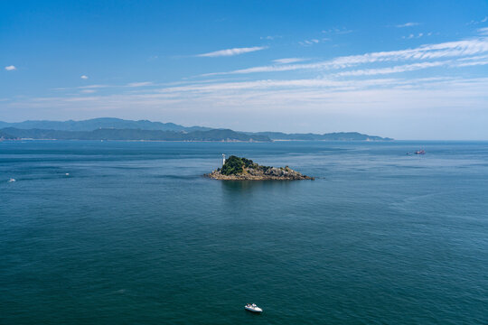 Tobishima Island with a white lighthouse floating in the Naruto Strait.