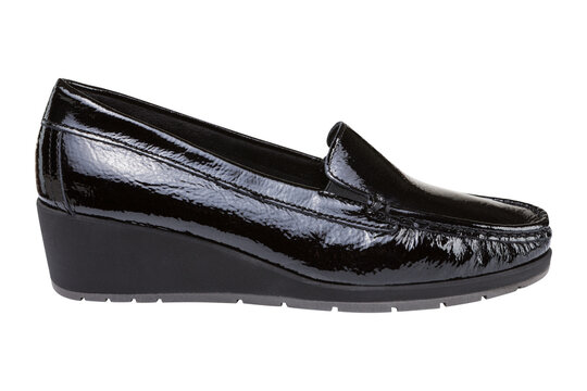 Women black patent leather wedge loafers isolated on white background. Casual shiny slip-on shoes, side view.