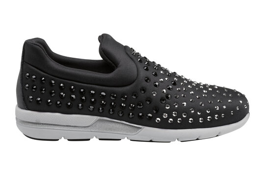 Women black slip-on sneakers with rhinestones isolated on white background. Casual sparkly sport shoes with silver crystals, side view.