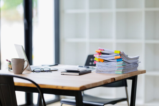 Stacks of paperwork accumulating on an office desk, highlighting heavy workload and administrative burdens