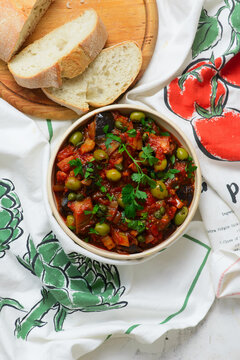 Traditional Sicilian caponata, a vegetable appetizer made with eggplant, olives, and capers in ceramic bowl