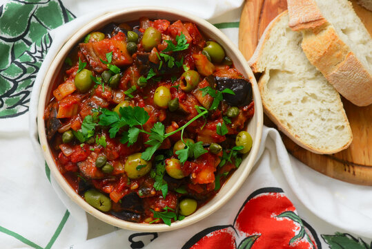 Traditional Sicilian caponata, a vegetable appetizer made with eggplant, olives, and capers in ceramic bowl
