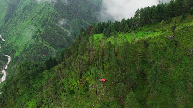 Aerial View of Red Roof Cabin in Pine Forest on Steep Mountain Ridge with River Stream