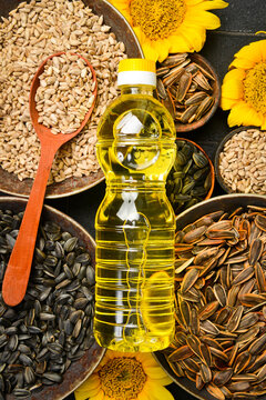 Assorted sunflower seeds served in rustic bowls around a fresh oil bottle. Essential organic ingredient for gourmet culinary recipes. Ideal background for food package concept.