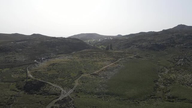 Cinematic aerial drone footage gliding over Serra da Freita revealing rugged granite landscapes, rolling plateaus, and vast natural scenery under soft daylight. Drone moving forward over the mountains
