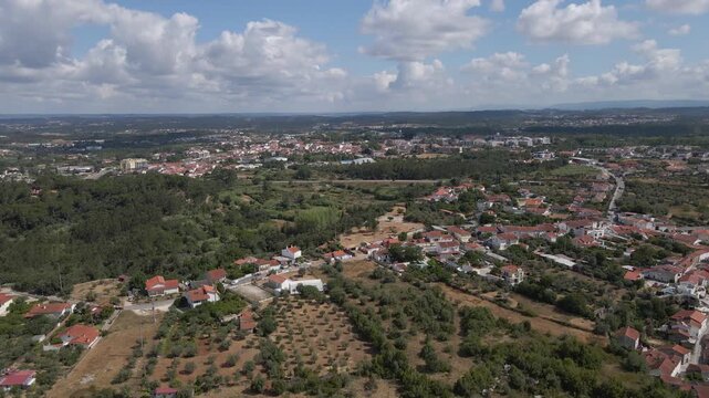 Cinematic aerial drone footage over Condeixa-a-Velha, Portugal, revealing the historic village, surrounding countryside, agricultural fields, and the ancient Roman heritage landscape of Con&iacute;mbriga.
