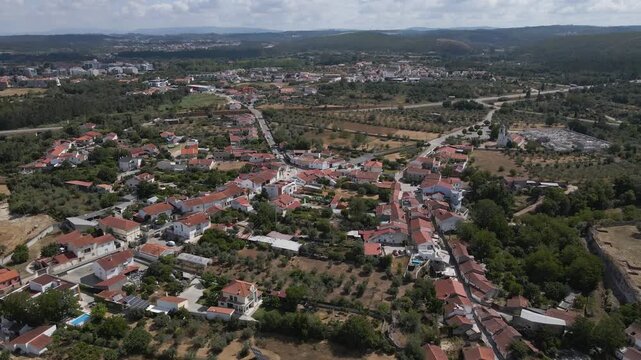 Cinematic drone footage of Condeixa-a-Velha highlighting historic landscapes, green countryside, village architecture, and the cultural heritage of the Coimbra region. Drone moving forward.