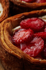 Obraz premium Macro detail of glossy strawberry slices and cream filling inside a crisp layered puff pastry tart