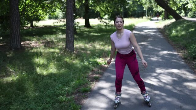 Young woman enjoys her favorite hobby of inline skating while cruising along a quiet park trail spending quality time outdoors on a warm summer afternoon