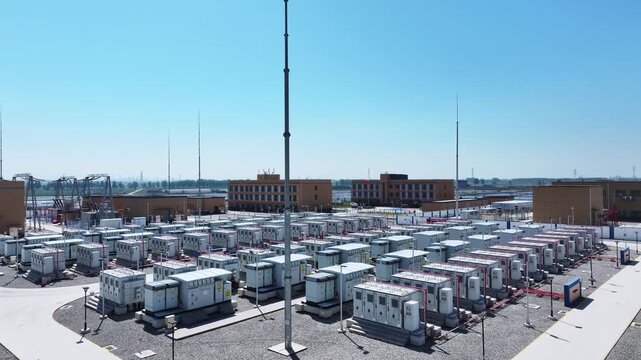 Large-scale substation with neatly arranged power equipment arrays under clear blue sky
