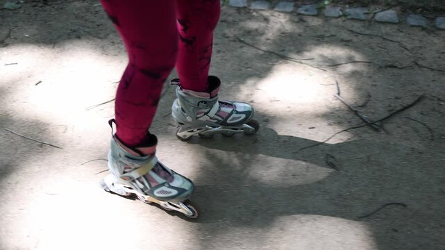 Close up of inline skates rolling across a rough forest trail because the city offers too few comfortable places for safe roller skating practice and training