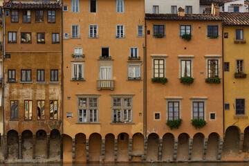 Authentic Italian architecture showcasing textured orange facades and stone arches over water, ideal for travel and heritage themes. © marcodenaro