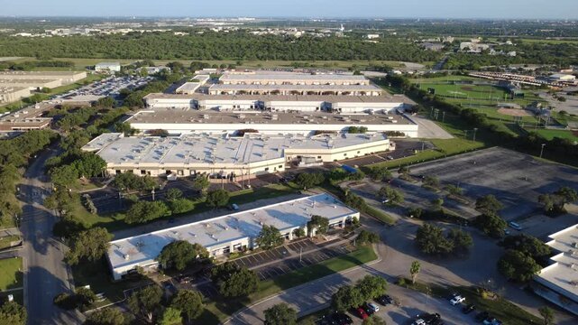 Extensive warehouse rooftops dominate industrial area within Alamo Downs Business Park corridor. Circular cul de sac connects flex offices to surrounding distribution facilities, San Antonio