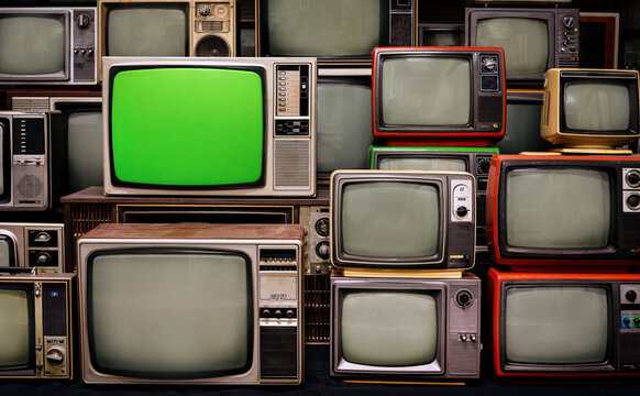 Vintage old televisions featuring a blank green chroma key screen in the room.