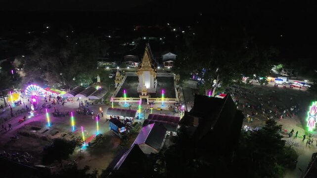 Discover the hidden cultural gem of Wat Sri Kaew temple fair in Nong Bua Lamphu, Thailand. This unseen perspective reveals the authentic charm of Isan culture under the night sky.