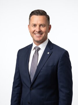 Confident Businessman in Blue Suit Smiling on White Background