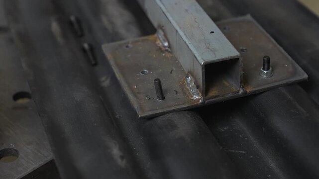 An engineer tightens a nut onto a bolt in a snowmobile ski mount