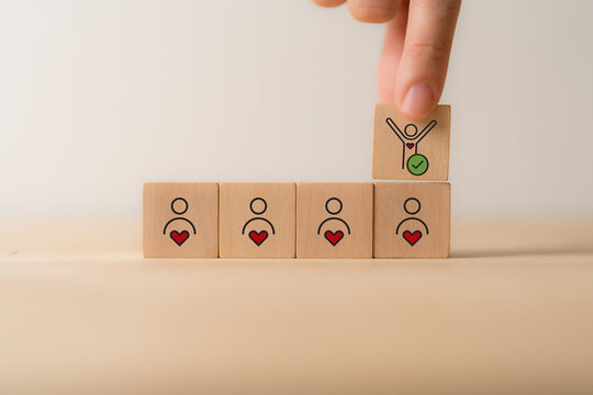 Employee Motivation or Brand Loyalty concept. Wooden blocks with employee blocks with heart symbols, representing motivation, brand loyalty, employee engagement, recognition and commitment.