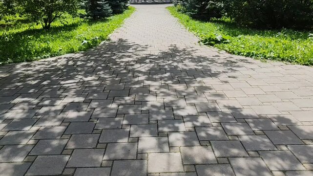Pathway to classical gazebo surrounded by greenery in a sunny park