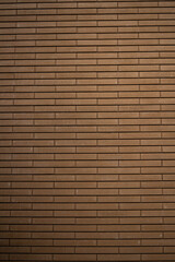 Obraz premium Textured brown brick wall with horizontal lines and subtle variations in color and pattern