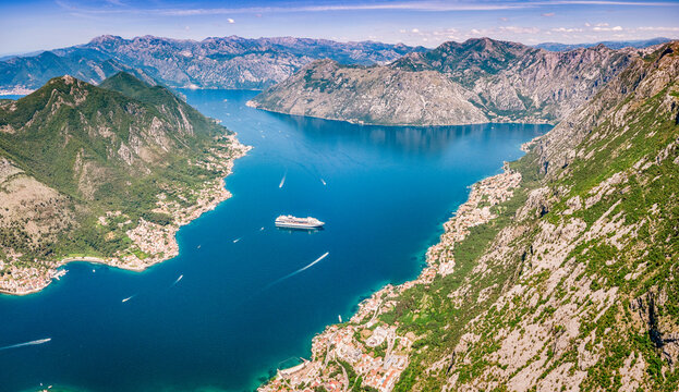 Bay of Kotor, Montenegro, from an aerial perspective, showing a cruise ship and many small boats moving on the blue water