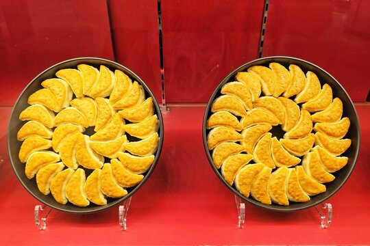 Two iron pans of delicious Japanese tetsu nabe gyoza dumplings displayed on red background for food and dining concept.