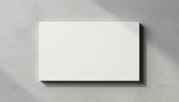 Minimalist flat-lay photograph of a light grey concrete surface with a white rectangular slab for modern design projects