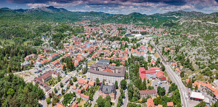 Cetinje, Montenegro, historic royal capital city with buildings and houses among green trees and surrounding mountains