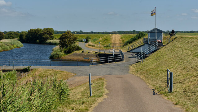 Coastal protection and water management at Sneum Sluse sluice gate Wadden Sea Coast Tjaereborg Denmark A sea dike with dyke roads and fences a canal