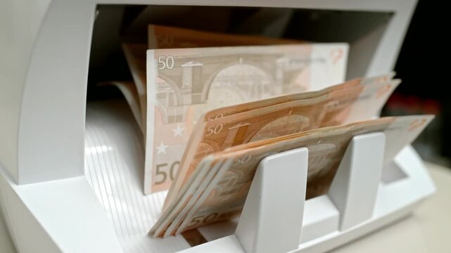 Fifty euro banknotes shuffling through the automatic money counter machine in slow motion for cash processing in 4K Ultra HD footage
